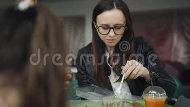 家吃中国面馆.. 母亲和两个女儿在一家咖啡馆吃午饭，喝新鲜胡萝卜汁。